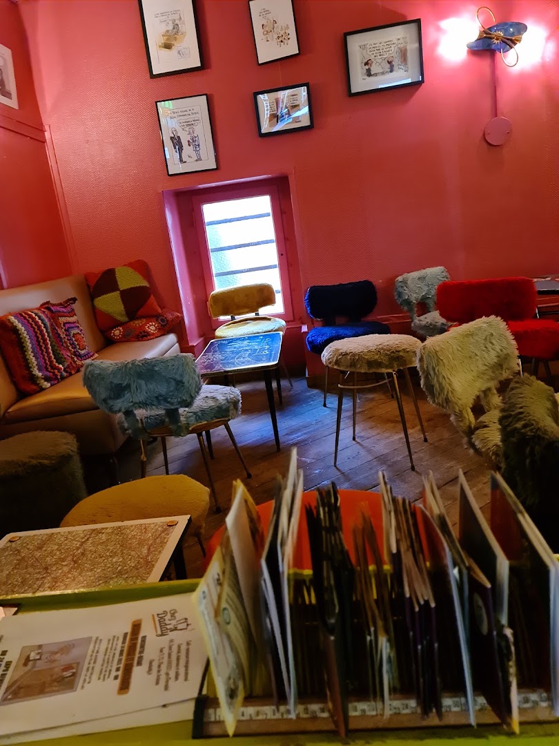 Un coin de salle avec mur rouge et fauteuils en velours