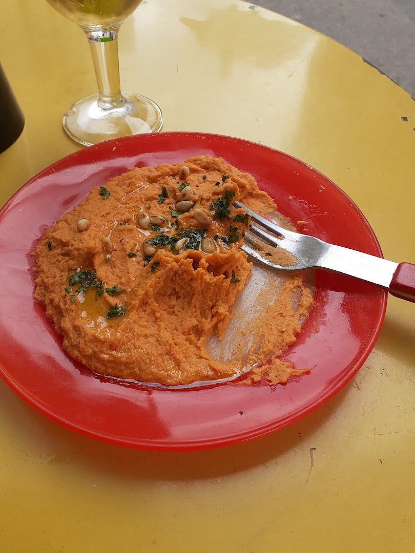 Un petit plat orange servi dans une assiette rouge