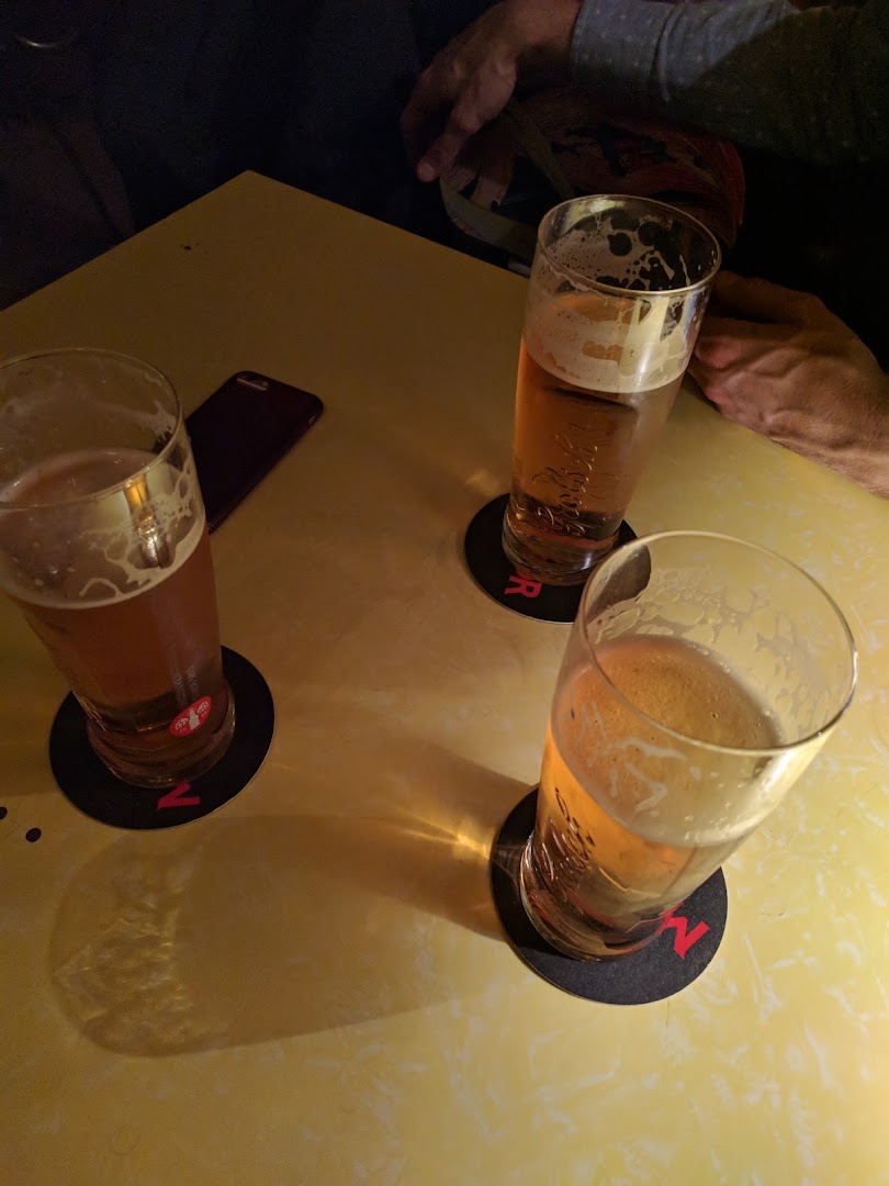 Trois verres de bière sur une table jaune