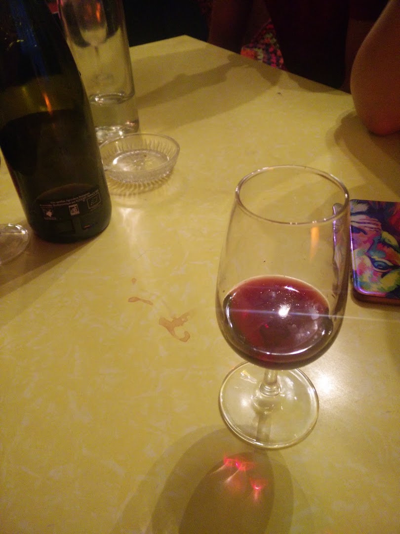 Un verre de vin rouge posé sur une table jaune